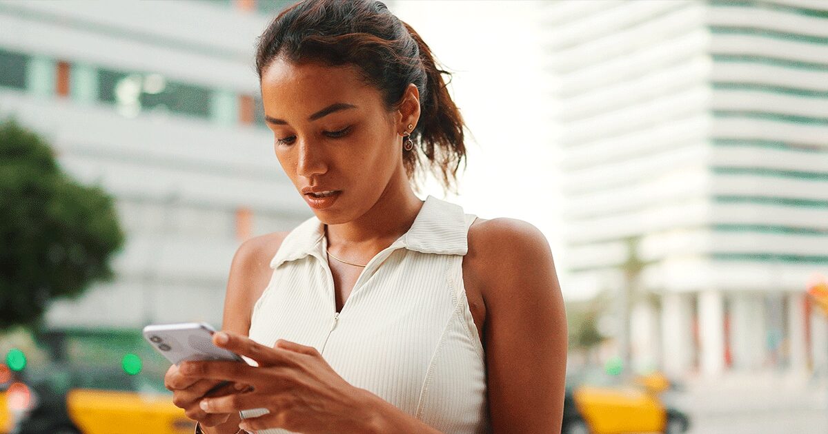 Young woman looking at her phone while researching whether an online abortion or abortion pill at home is safe.